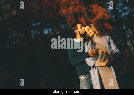 Schwangere Frau und Mann posiert im Herbst park Stockfoto