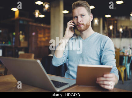 Besetzten Geschäftsmann Multitasking im Café mit Technologie Stockfoto
