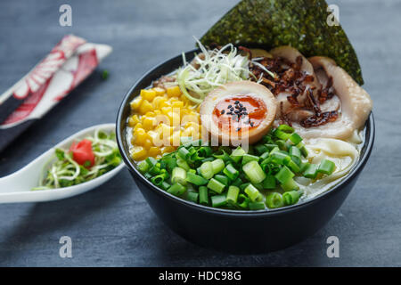 japanische Tonkotsu Ramen Nudeln Schweinefleisch Knochen Brühe mit Chashu, Ei, Mais und Frühlingszwiebeln Stockfoto