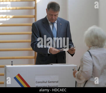 Bukarest, Rumänien - 5. Mai 2016: Der rumänische Präsident Klaus Iohannis wirft seine Stimme bei den Kommunalwahlen. Stockfoto