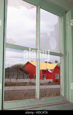 Altes rotes Gebäude, das durch ein kaputtes Fenster in der Estancia San Gregorio in Patagonischem Chile gesehen wurde Stockfoto