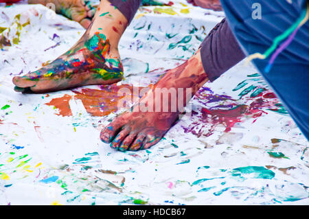 Kinder spielen, farbenfrohen Designs mit ihren Füßen in der bunten Tempera eingetaucht Stockfoto