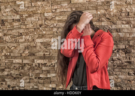 Teenager-Mädchen verstecken Gesicht mit Händen erschrocken Stockfoto
