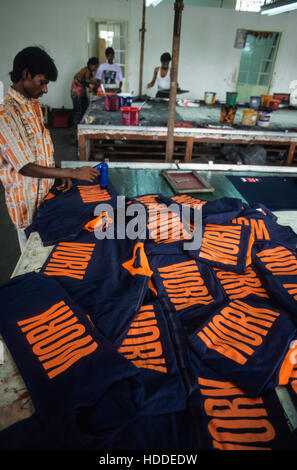 Indien, Tamil Nadu, Tirupur, Textilfabrik, Arbeitnehmer drucken T-Shirts mit dem Wort für den Export arbeiten - Bekleidung Kleidung T-Shirt Druck Drucken cloting Schreiben Stockfoto