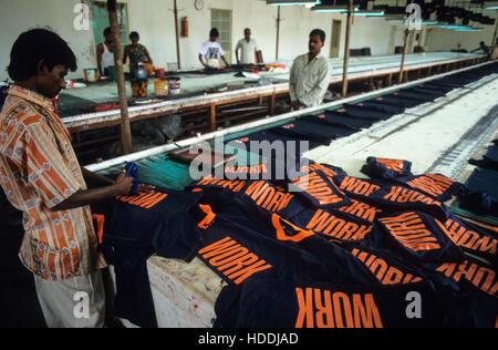 Indien, Tamil Nadu, Tirupur, Textilfabrik, Arbeitnehmer drucken T-Shirts mit dem Wort für den Export arbeiten - Bekleidung Kleidung T-Shirt Druck Drucken cloting Schreiben Stockfoto