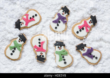 Hausgemachte Schneemänner Kekse auf einem verschneiten Hintergrund. Stockfoto