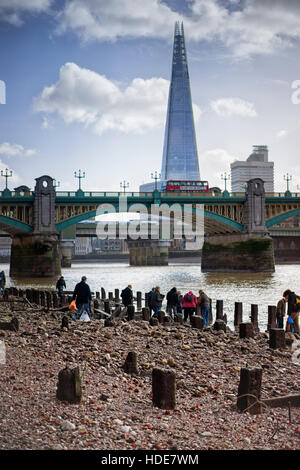 Ebbe am Themse Ufer unter Southwark Bridge in London, wo Besucher auf Gegenstände Jagd, angespült, vor die Scherbe. Stockfoto