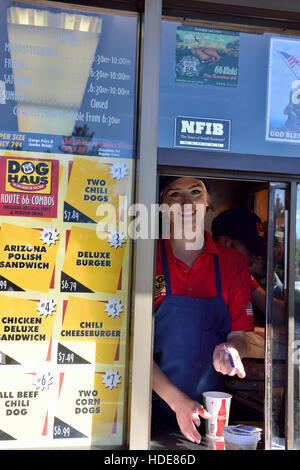 Attraktive Kellnerin serviert am Fenster im Route 66 Hund Haus Teil des Fast-Food-Restaurant-Kette wurde formal Weinerschnitzel, Flagstaff, Arizona Stockfoto