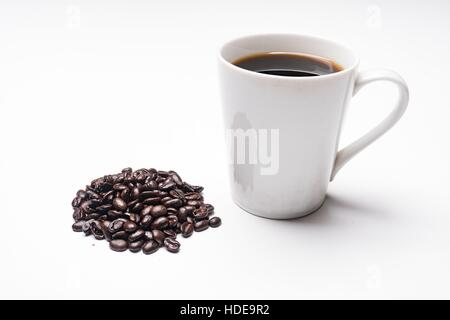 Kaffeetasse mit Kaffee und Haufen von Bio Kaffeebohnen neben Tasse gefüllt. Stockfoto