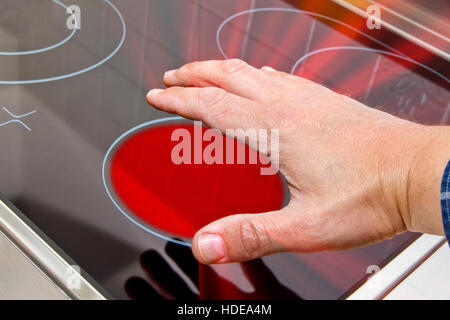Mann berühren eine Herdplatte Stockfoto