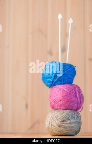 Knäuel Wolle und Stricknadeln auf einem Holztisch Nahaufnahme Stockfoto