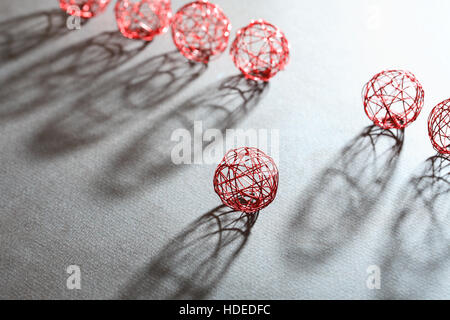 Set mit Kugeln aus roter Draht in einer Reihe mit Schatten Stockfoto