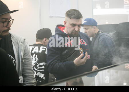 Moskau - 9. Dezember 2016: International Vape Expo.Russian Rap-star, berühmte Rapper Sänger Basta versuchen neue dampfen Gerät und Vaper flüssigen Ejuice. Stockfoto