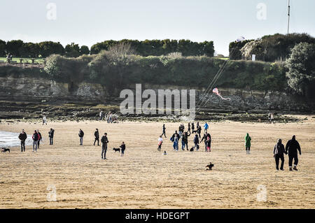 Menschen fliegen Drachen und gehen Hunde am Strand von Barry Island, Vale of Glamorgan, Wales, wo klare Himmel und strahlendem Sonnenschein Südwales Küste dominieren Dezember Temperaturen weiterhin mild. Stockfoto