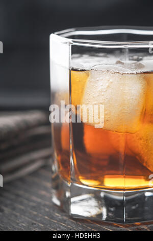 Whisky mit Eis auf dem Holztisch vertikale Stockfoto