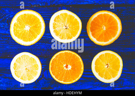 Zitrone und orange Scheiben auf dem blauen hölzernen Hintergrund Ansicht von oben Stockfoto