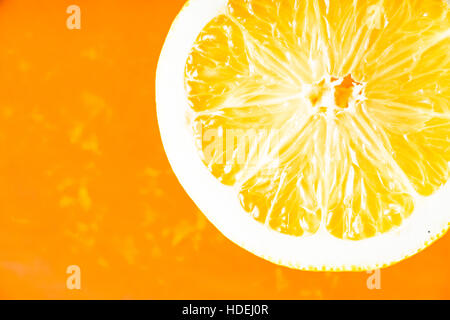 Orangenscheibe im orangefarbenen Hintergrund Stockfoto