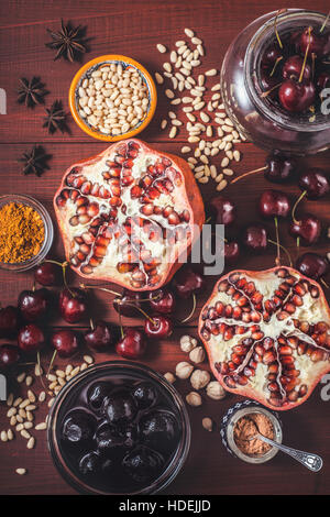 Verschiedenen Früchten und Gewürzen auf den roten Holztisch. Konzept der vertikalen orientalische Früchte Stockfoto