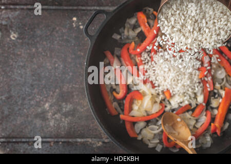 Hinzufügen von Reis in der Pfanne mit gerösteten Gemüse Draufsicht Stockfoto