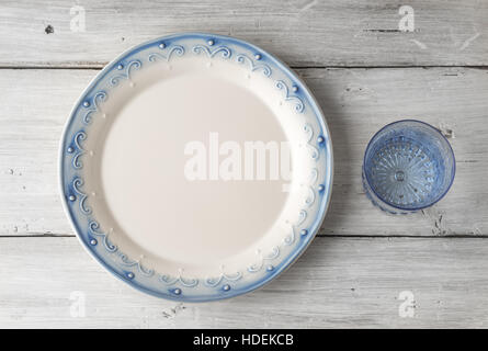 Teller und Glas auf der weißen hölzernen Tischplatte anzeigen Stockfoto