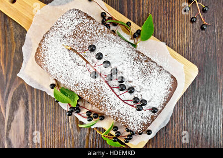 Früchtebrot Vogel-Kirsche mit Beeren auf einem Papier auf dem Hintergrund der Top-Holzbrett Stockfoto