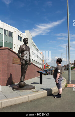 Junger Mann bewundern die Statue von Jimmy Armfield, ehemaliger Spieler und Kapitän der Blackpool Football Club. Stockfoto