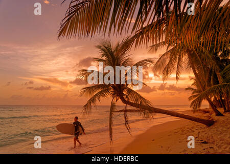 Surfer und Sonnenuntergang in Dover Beach, St. Lawrence Gap, Südküste, Barbados, Karibik. Stockfoto