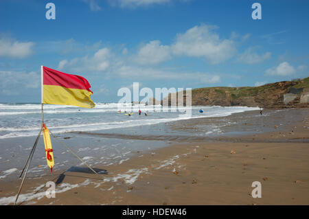 Eine rote und gelbe RNLI Strand Sicherheitsflagge am Crooklets Strand bezeichnet einen Bereich von Rettungsschwimmern bewacht. Stockfoto