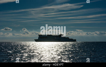 Die Insel inishmore irischen Fähre Ansätze Milford Haven auf einem gläsernen Meer unter blauem Himmel mit Cirrus und cumulus Wolken. Stockfoto