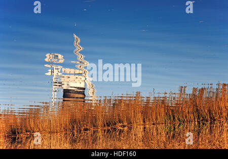 Eine Reflexion der St Benet Ebene Entwässerung Mühle in den Fluß Thurne auf den Norfolk Broads. Stockfoto