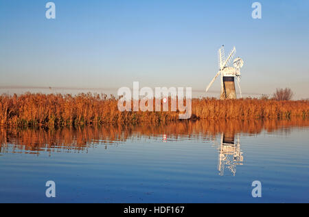 Ein Blick auf St. Benet Ebene Entwässerung Mühle durch den Fluß Thurne vom Thurne, Norfolk, England, Vereinigtes Königreich. Stockfoto