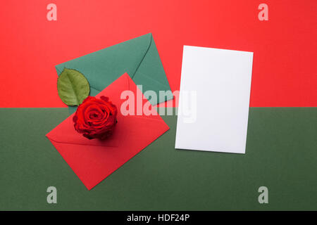 Rote und grüne Umschläge auf Weihnachten Urlaub Hintergrund. Flach zu legen. Stockfoto