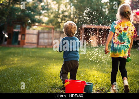 Rückansicht von jungen und Mädchen auf Spielplatz. auf dem Rasen. Stockfoto