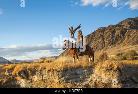 Bayan-Ulgii, Mongolei, 2. Oktober 2015: Alte Adler Jäger mit seinem Altai Steinadler auf seinem Pferd Stockfoto