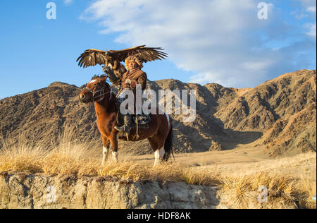 Bayan-Ulgii, Mongolei, 2. Oktober 2015: Alte Adler Jäger mit seinem Altai Steinadler auf seinem Pferd Stockfoto