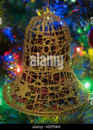 Goldene Glocke einen beleuchteten Weihnachtsbaum Dekoration Stockfoto
