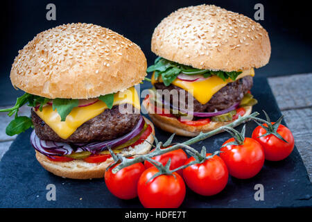 Hausgemachte Rindfleisch-Burger auf schwarzem Schiefer Hintergrund. Stockfoto