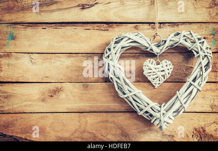 Zwei rustikale dekorative Holzherzen Vintage Holz-Hintergrund mit Raum hängen. Stockfoto