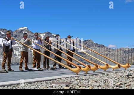 Sechs Schweizer Alphorn-Gebläse auf einem Schweizer Berggipfel Stockfoto