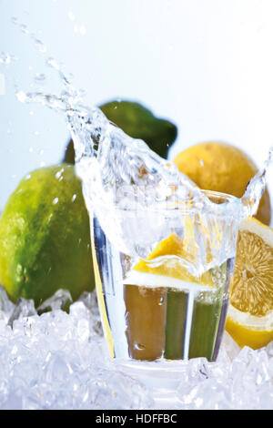 Zitrone in ein Glas Wasser fallen Stockfoto