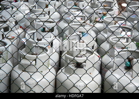 Gasflaschen in einer Zeile hinter einem Zaun für den Hintergrund verwenden Stockfoto