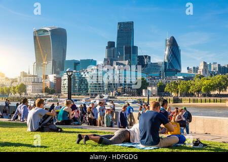 LONDON, der Königin Südufer Fuß London. Touristen genießen Sie Sonne und Schatten von Tower Bridge auf der Southbank der Themse Stockfoto