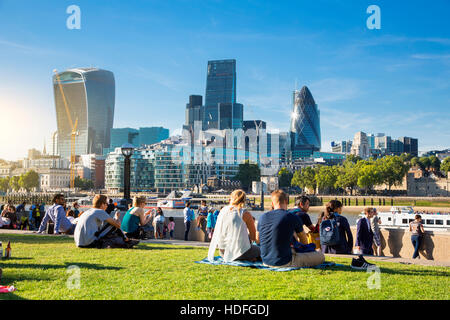 LONDON - die Königin Südufer Fuß London. Touristen genießen Sie Sonne und Schatten von Tower Bridge auf der Southbank der Themse Stockfoto