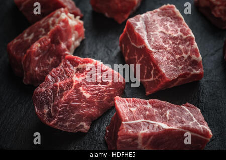 Rohe Angus-Rindfleisch-Scheiben auf den schwarzen Stein Tisch horizontal Stockfoto