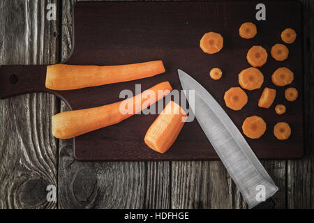 Schneiden Karotten auf dem Holzbrett-Draufsicht Stockfoto
