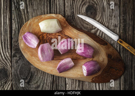 Schalotten auf dem Holzbrett mit Messer-Draufsicht Stockfoto