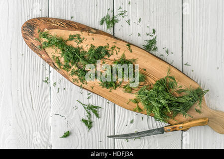 Dill auf die natürliche Holzbrett auf die weiße Tischplatte-Ansicht Stockfoto