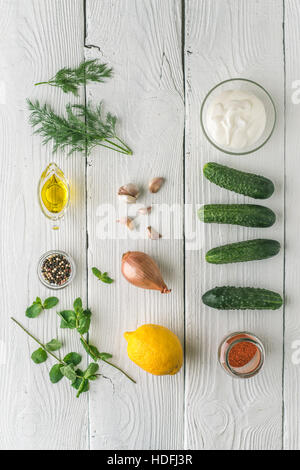 Zutaten für Tzatziki auf dem vertikalen weißen Holztisch Stockfoto