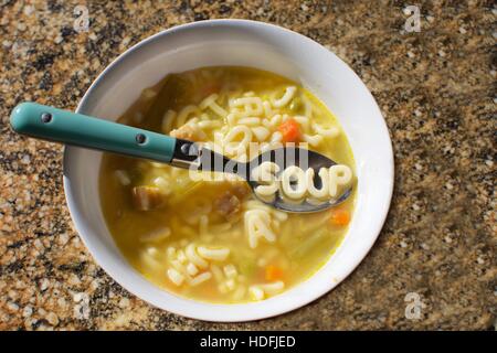 Buchstabensuppe mit der Wort-Suppe auf dem Löffel in Nudeln geschrieben Stockfoto