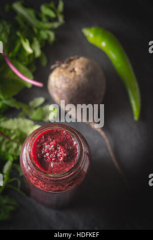 Gemüse-Smoothie mit unscharfen Zutaten auf dem dunklen Stein Hintergrund vertikale Stockfoto